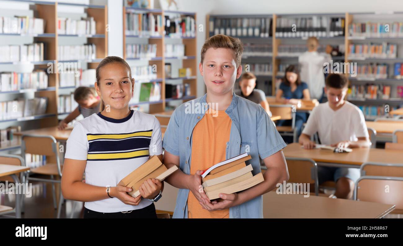 Portrait of cheerful boy and girl holding books Stock Photo - Alamy