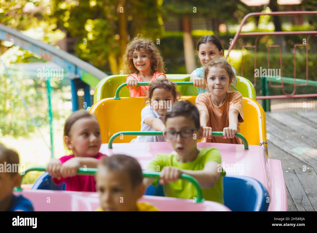 The happy kids on a roller coaster in the amusement park Stock Photo ...