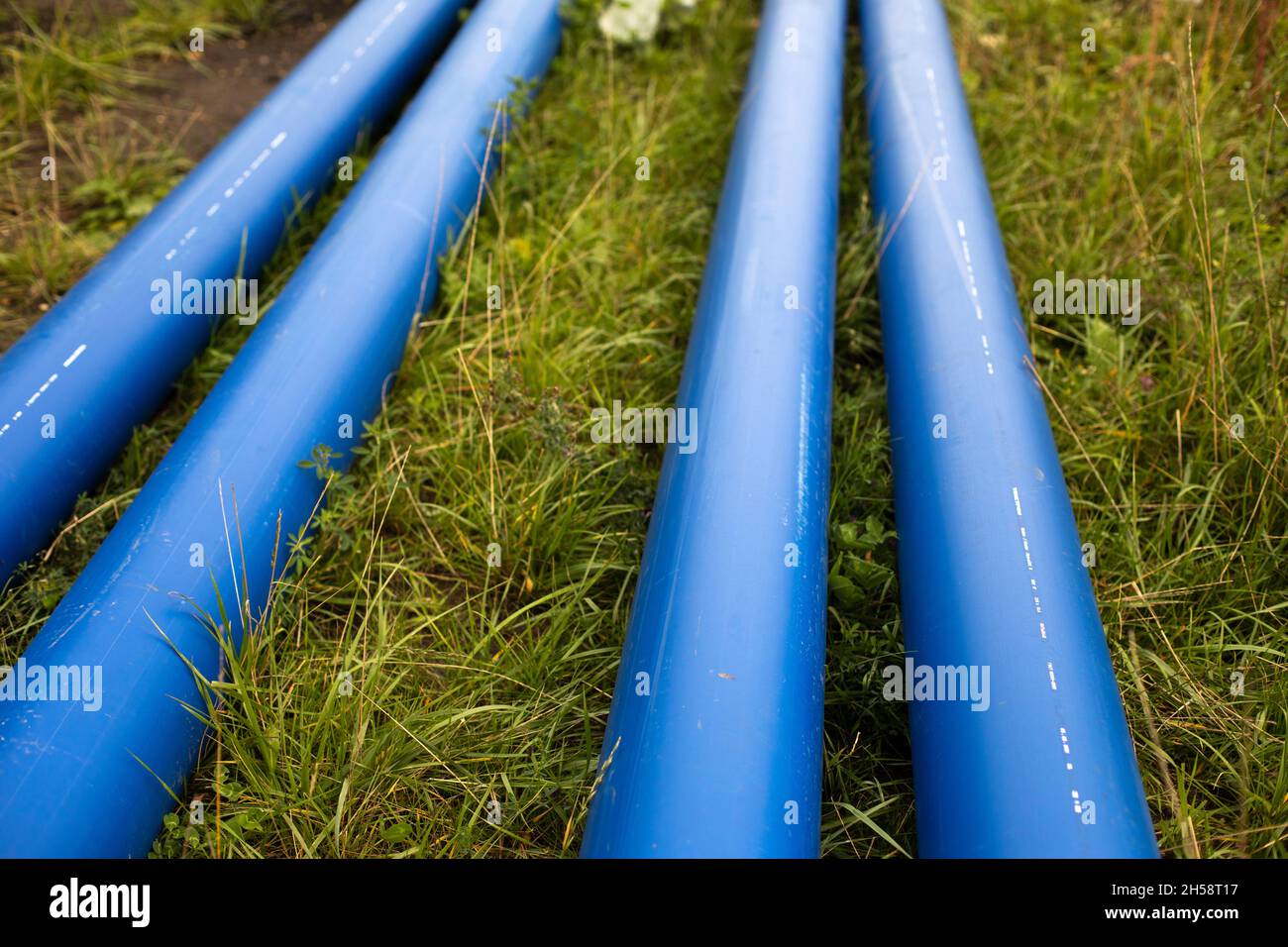 Blue water pipes. Industrial pipes lie on the ground. Details of laying
