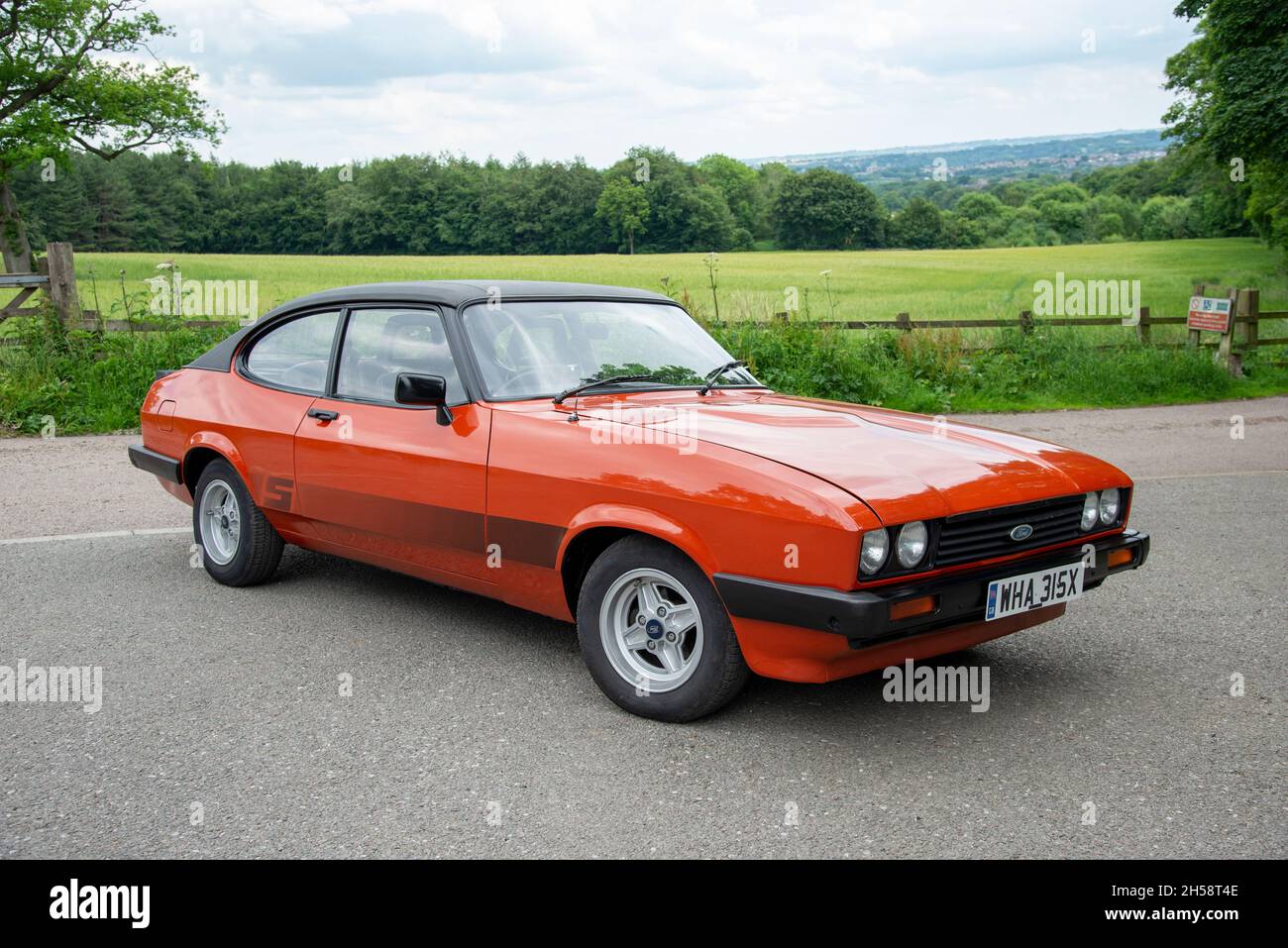 Ford Capri 1.6S with vinyl roof parked on a country lane in Summer with fields and trees behind Stock Photo