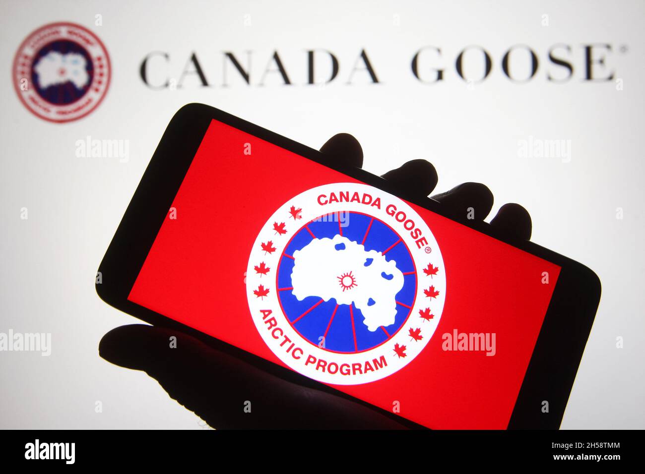 In this photo illustration, a Canada Goose Holdings Inc. logo is seen on a  smartphone and a pc screen Stock Photo - Alamy