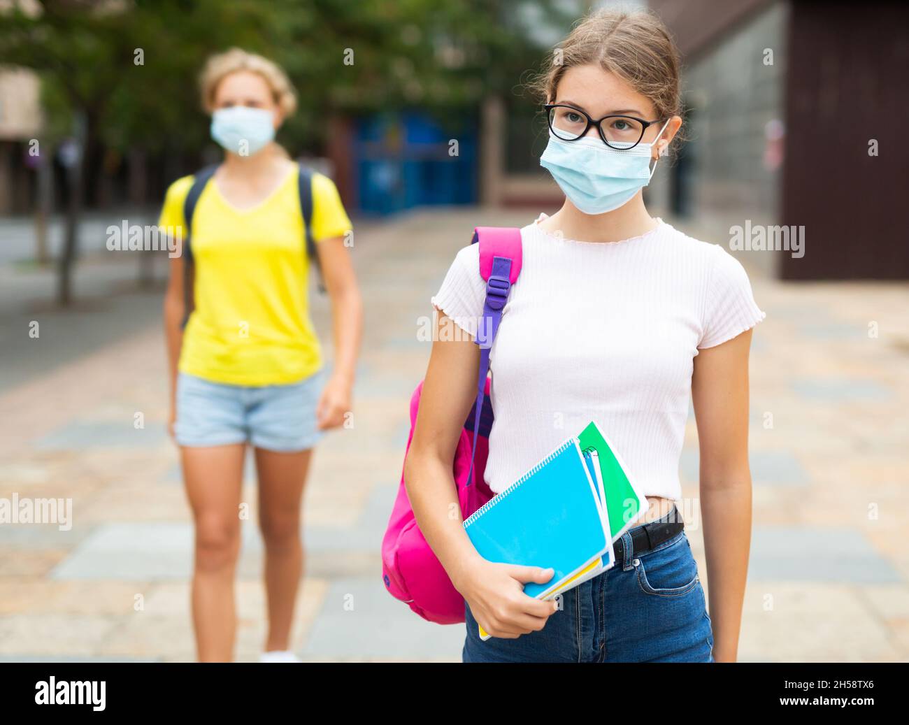 Two young girls in face masks outdoors Stock Photo - Alamy