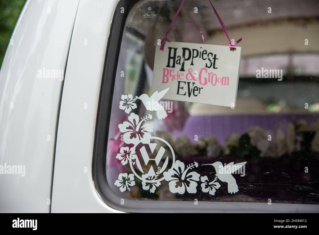 'Happiest Bride and Groom' notice in rear window of VW Camper Van Stock Photo