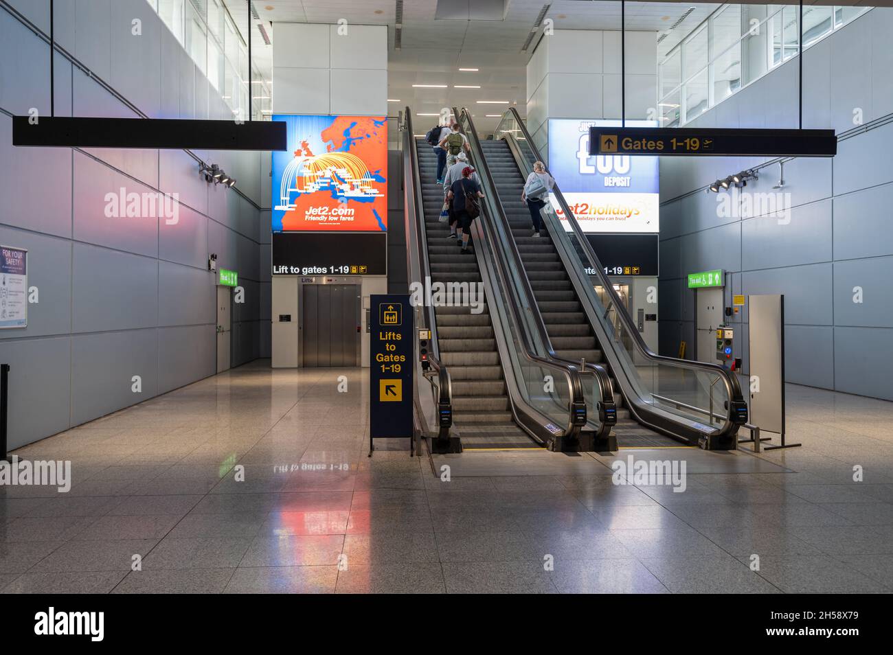 06/09/2021. Stansted Airport, UK. A few passengers with hand luggage on escalators heading towards departure gates. Stock Photo