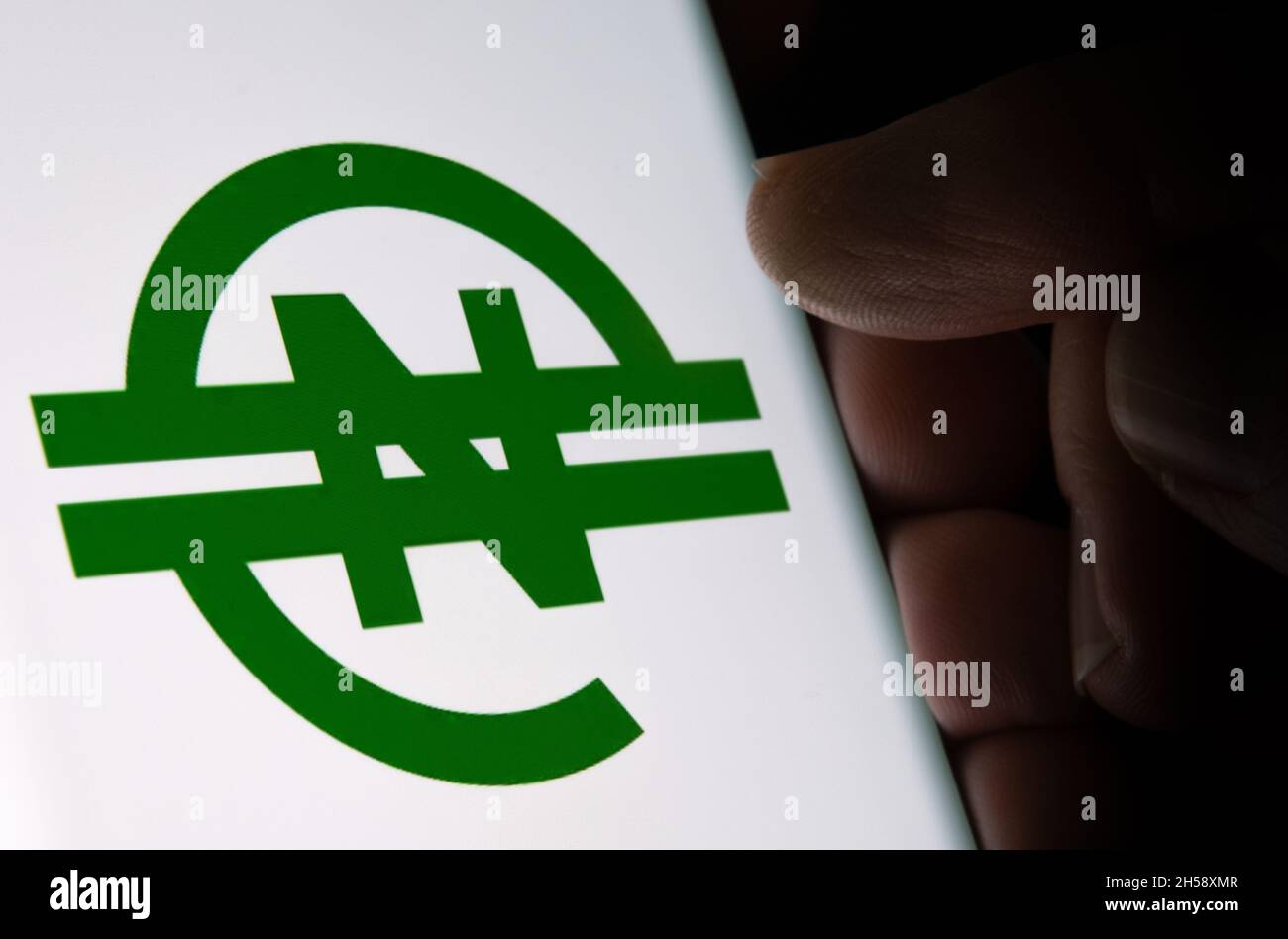 eNaira currency logo seen on glowing screen and finger touching it. Africa’s first digital currency. Stafford, United Kingdom, November 7, 2021. Stock Photo