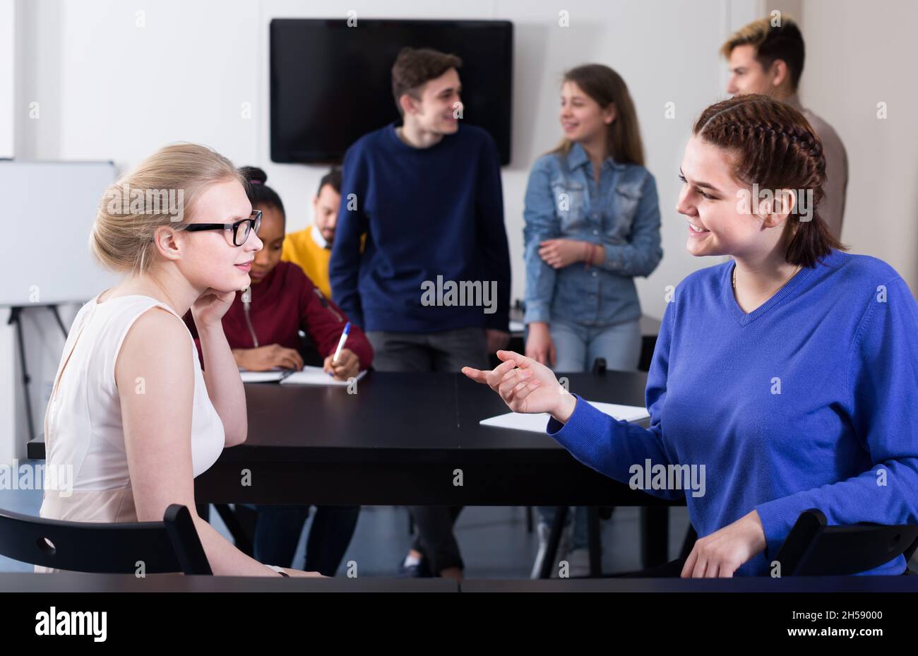 interested classmates having animated talks at break between classes ...