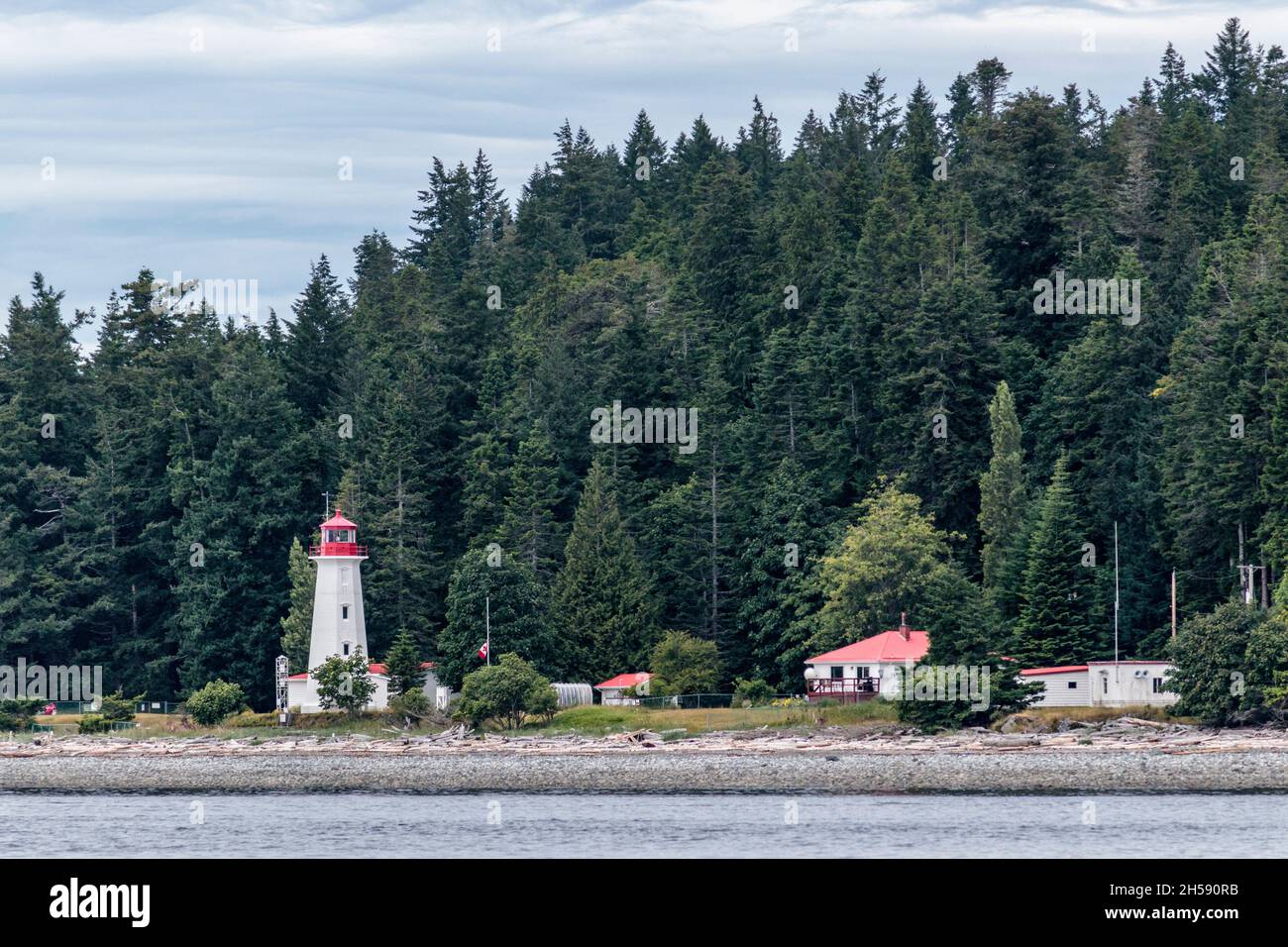 A view of the beach, buildings, tower and forest at historic, but still operational Cape Mudge Lighthouse, on Quadra Island along BC's Inside Passage. Stock Photo