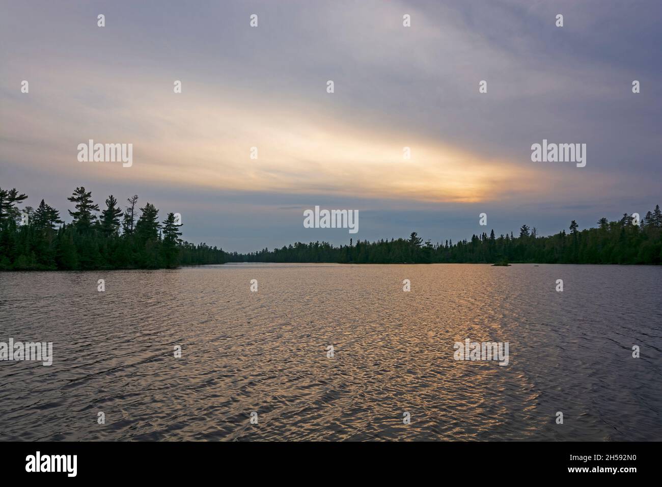 Sun Glow at Twilight on a North Woods Lake on Horseshoe Lake in the Boundary Waters in Minnesota Stock Photo
