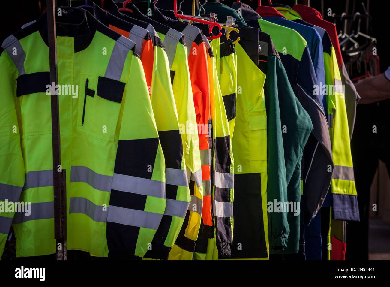 Picture of personal protective equipment for sale, made of high visibility fluo jackets and coats, yellow or orange. Such workwear is used by staff wi Stock Photo