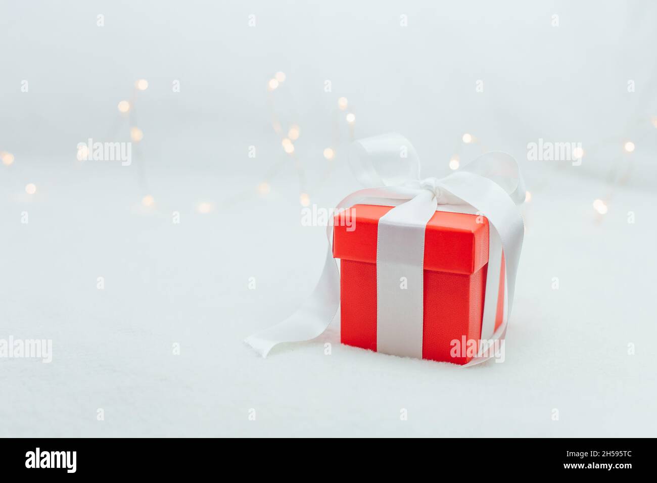 Red gift box bandaged whith a white ribbonon the white background with ...