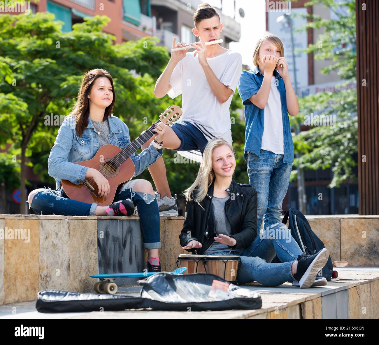 Friends musicians playing by instruments in park Stock Photo Alamy