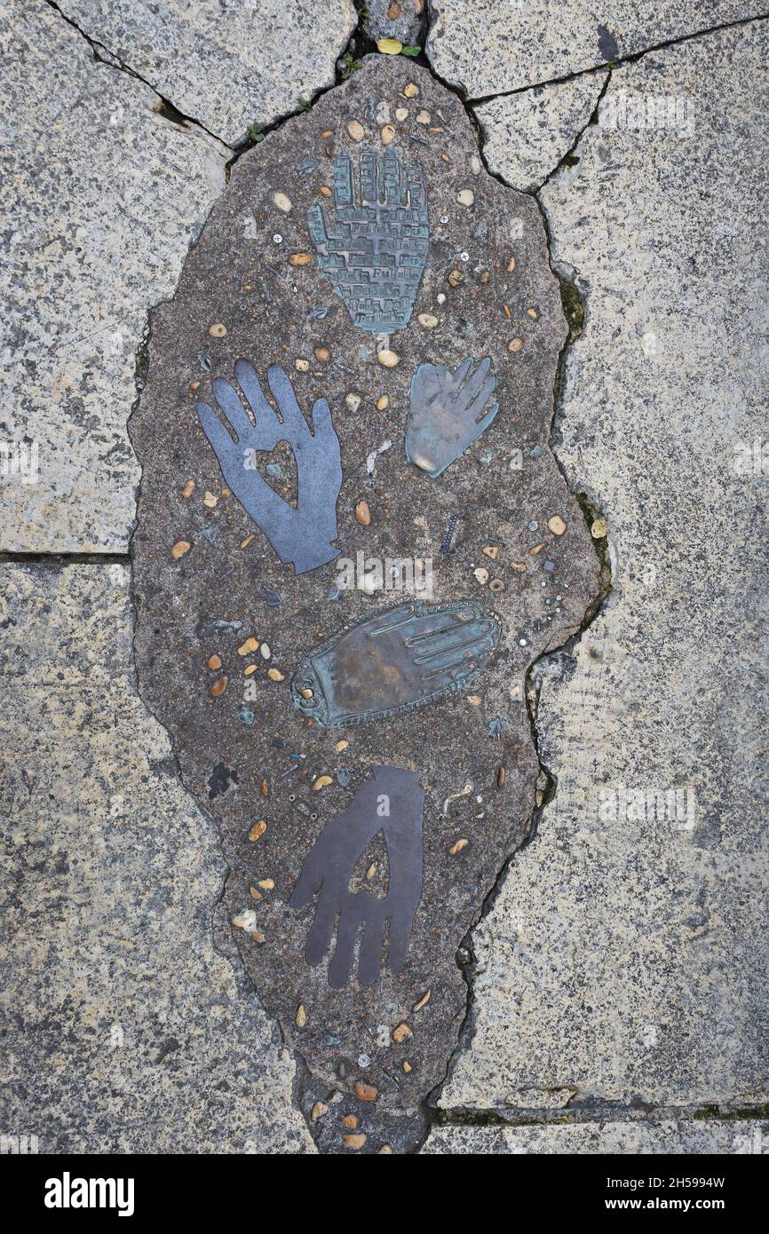 Metal hands imbedded in the sidewalk along the riverwalk in San Antonio, Texas. Stock Photo
