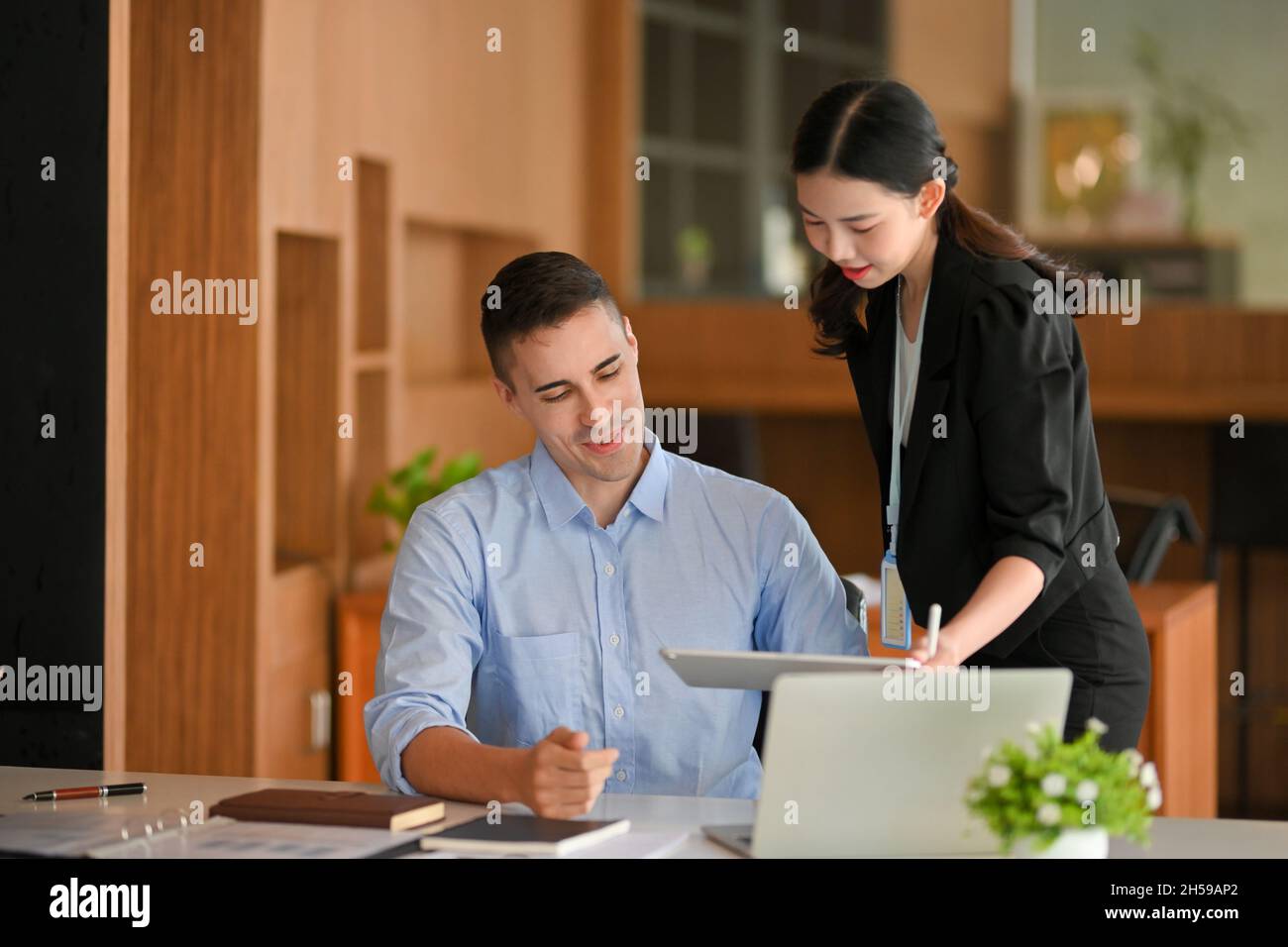 Business female manager shows business informations via tablet computer to her caucasian male staff Stock Photo