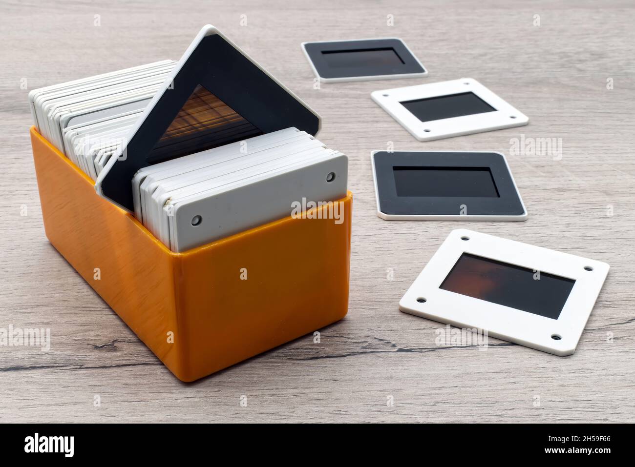 Old slides in a plastic box. Vintage 35mm slide film on wooden table