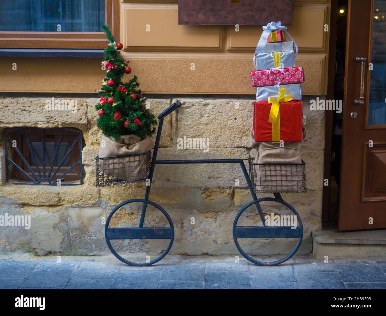 Christmas decorative bicycle with a lot of gift boxes and decorated fir tree Stock Photo