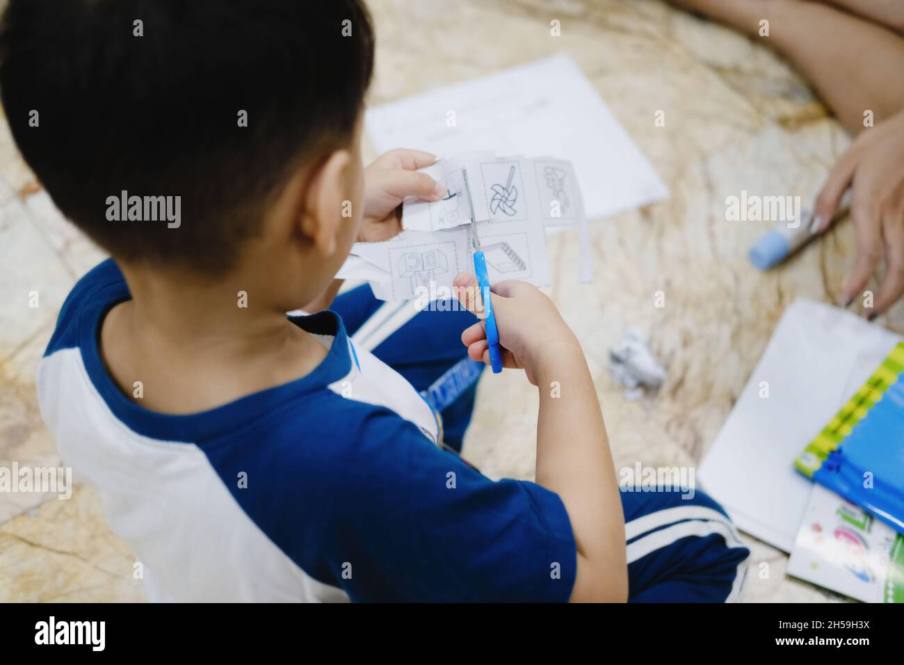 Childhood are learning to use scissors to cut paper Stock Photo - Alamy