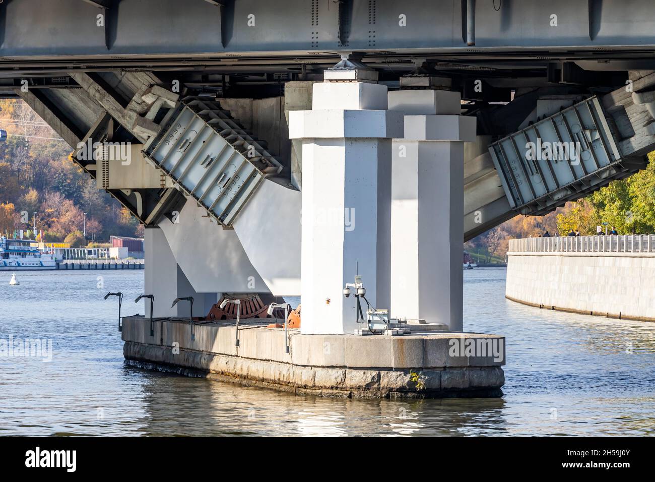 Highway bridge arch and structural supports against a river Stock Photo ...