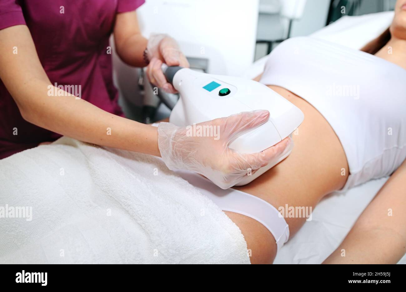 Attractive woman in white bikini getting Cool sculpting procedure for body slimming. Cryolipolyse and body contouring treatment, anti-cellulite and an Stock Photo