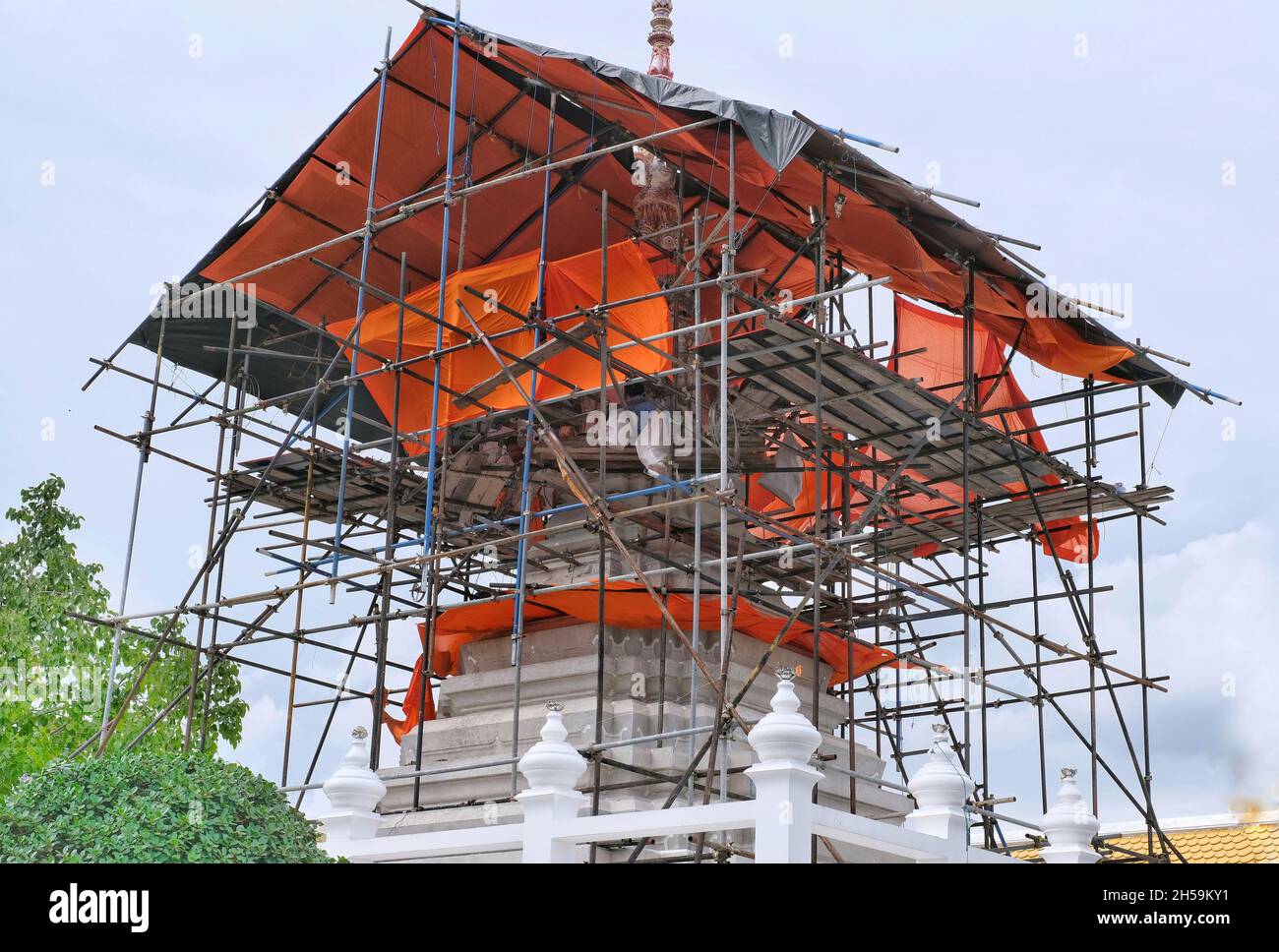 Bangkok / Thailand - 2021/11/01: A large white pagoda at Wat Pariwat temple under construction with scaffolding and temporary roofing. Stock Photo