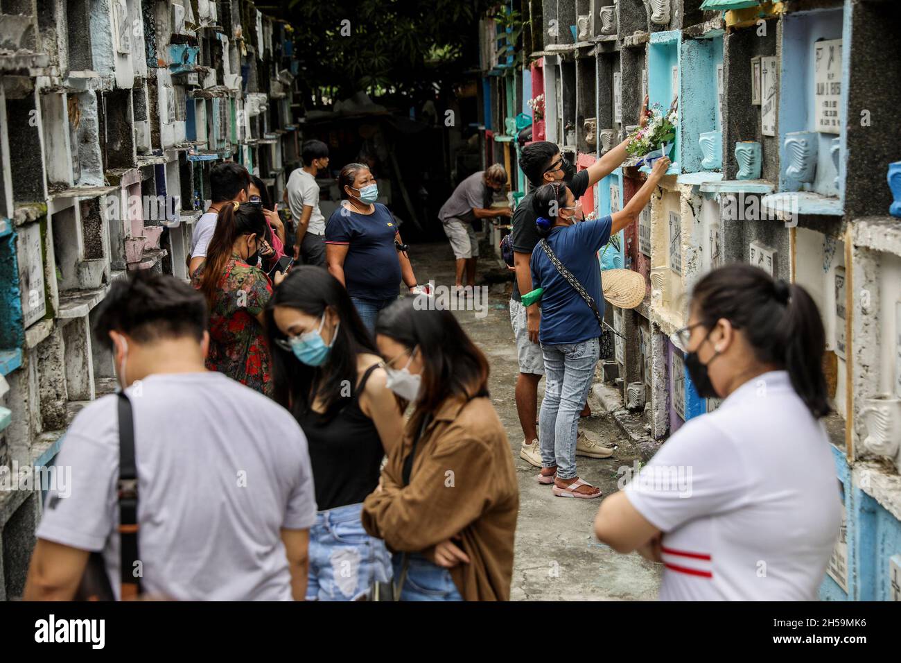 People visit their departed loved ones in observance of All Souls’ Day inside a public cemetery. Quezon City, Metro Manila, Philippines. Stock Photo