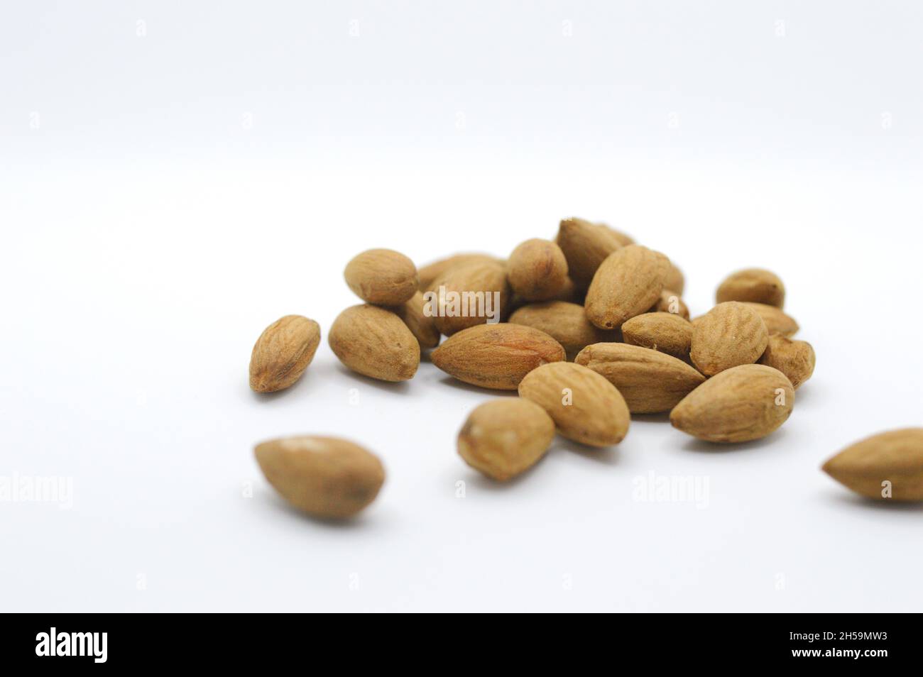 Raw organic healthy almonds on horizontal white backdrop Stock Photo