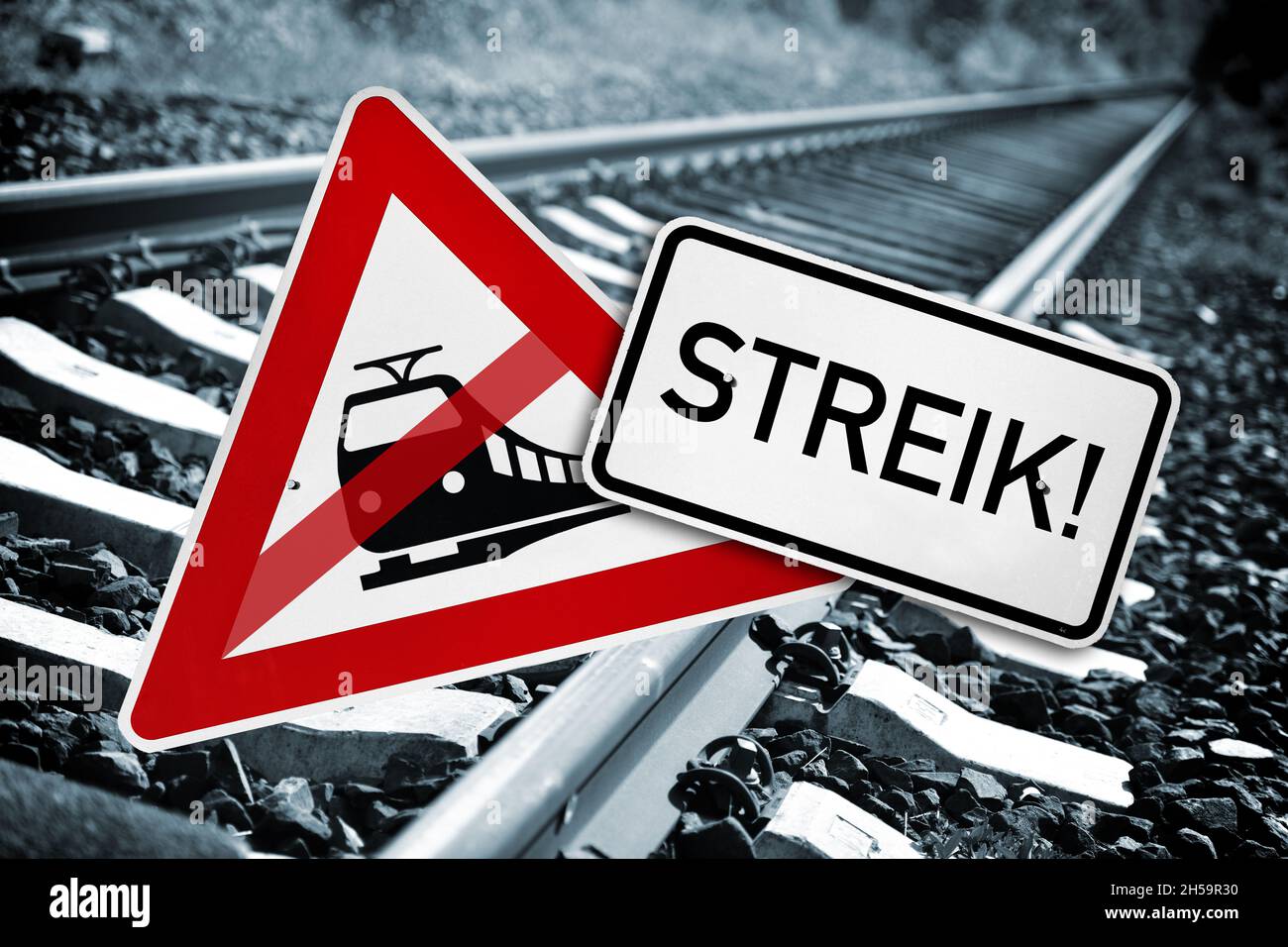 FOTOMONTAGE, Durchgestrichenes Verkehrsschild Bahnübergang und Schild mit Aufschrift Streik vor leeren Bahngleisen, Symbolfoto Bahnstreik Stock Photo