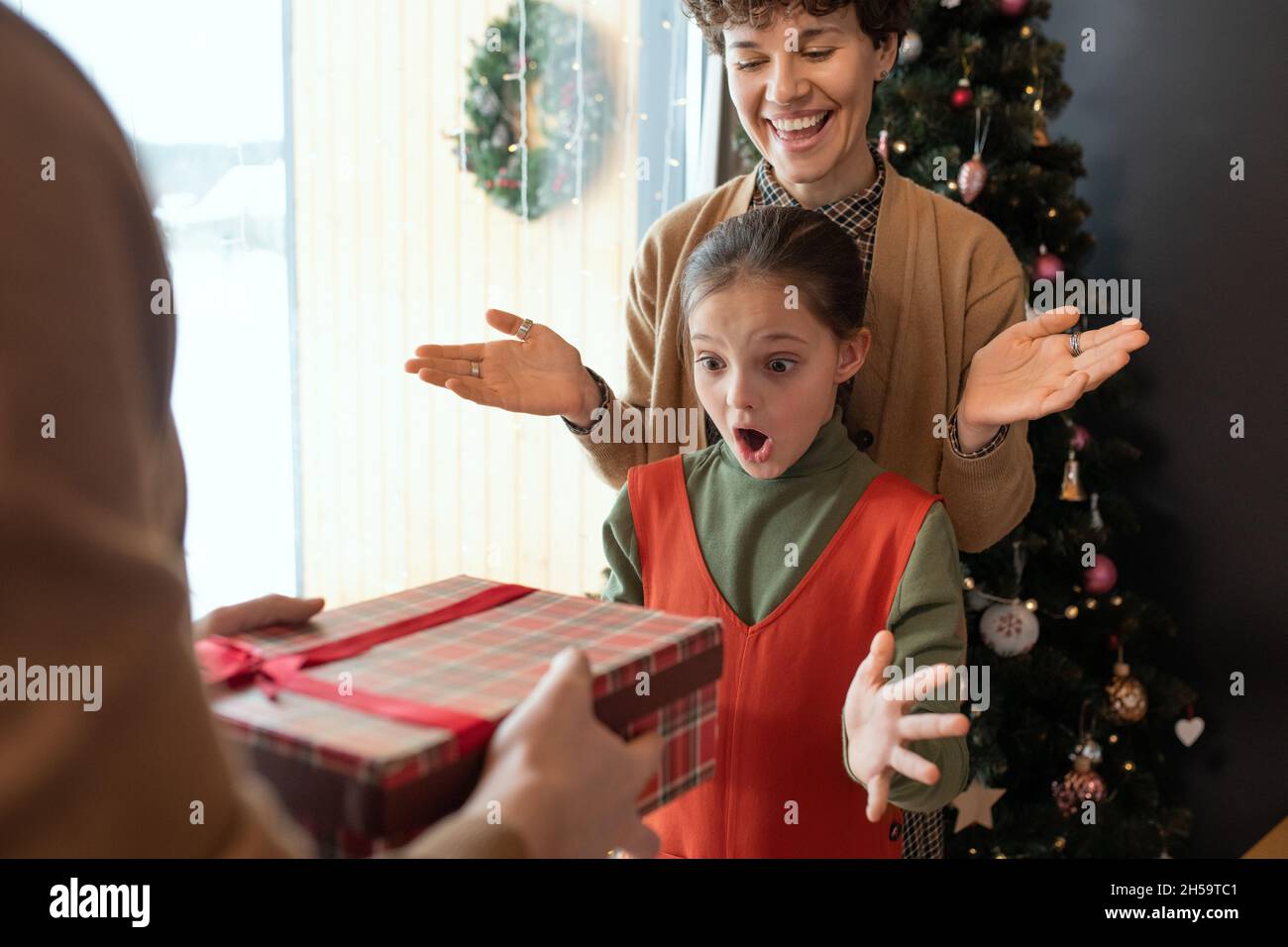 Amazed girl throwing hands up and keeping mouth open while getting