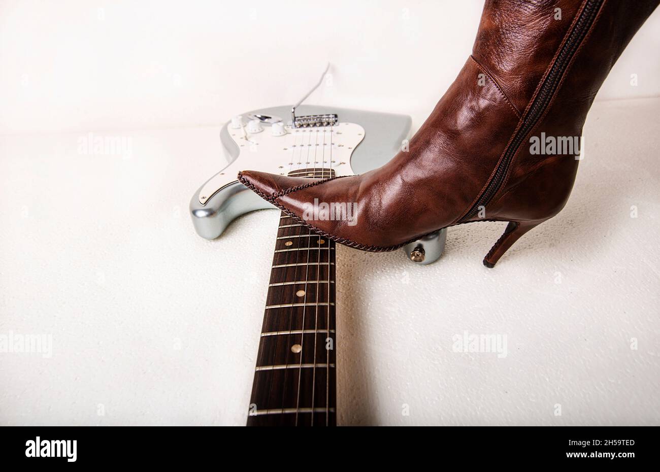 Silver electric guitar and brown women's high heels boot Stock Photo Alamy