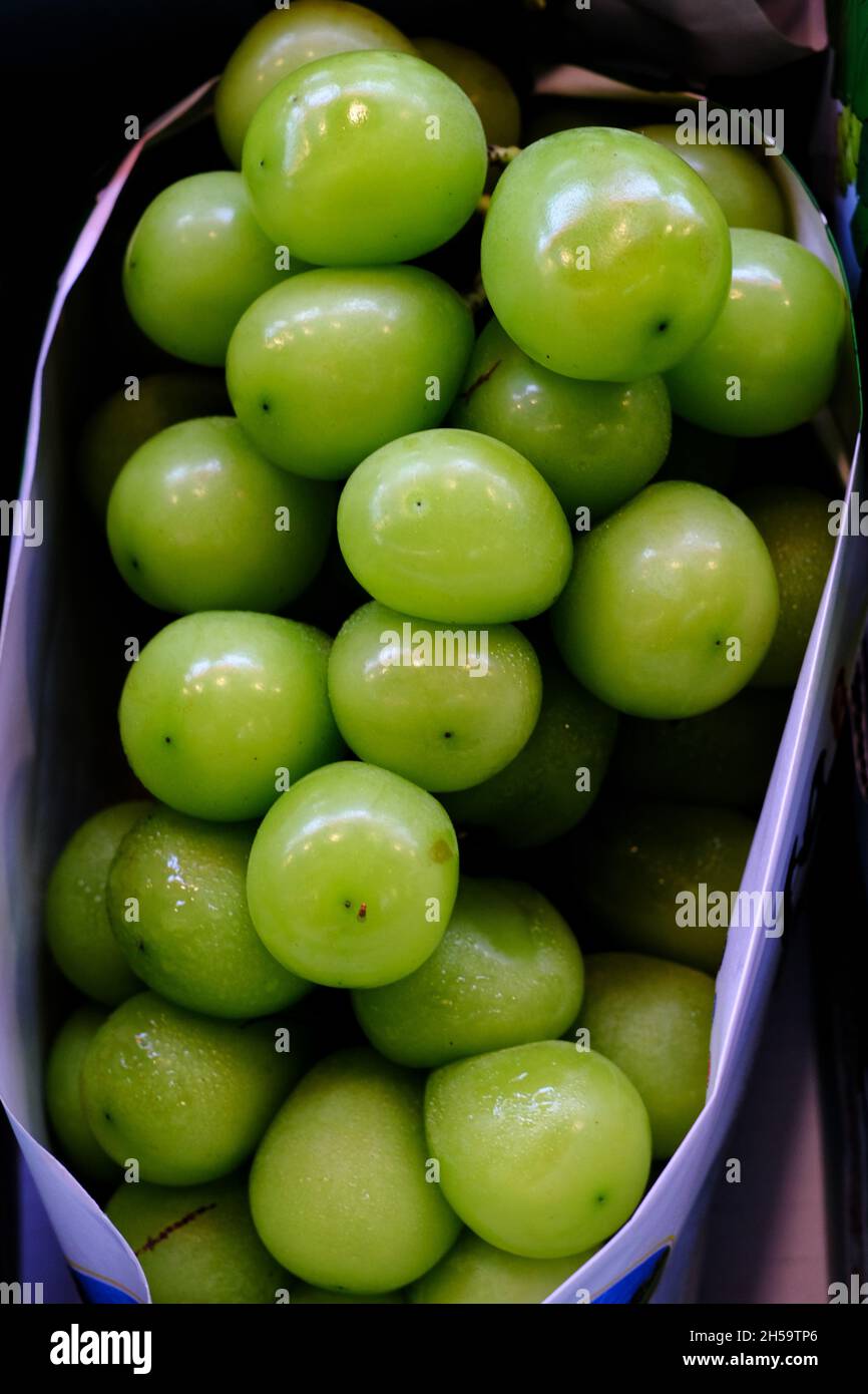 A bunch of ripe green grapes, nicely packaged in a box at a fresh ...