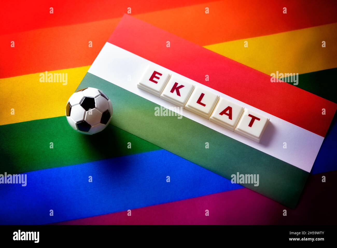 Miniaturfußball auf Fahne von Ungarn und Regenbogenfahne mit dem Schriftzug Eklat Stock Photo