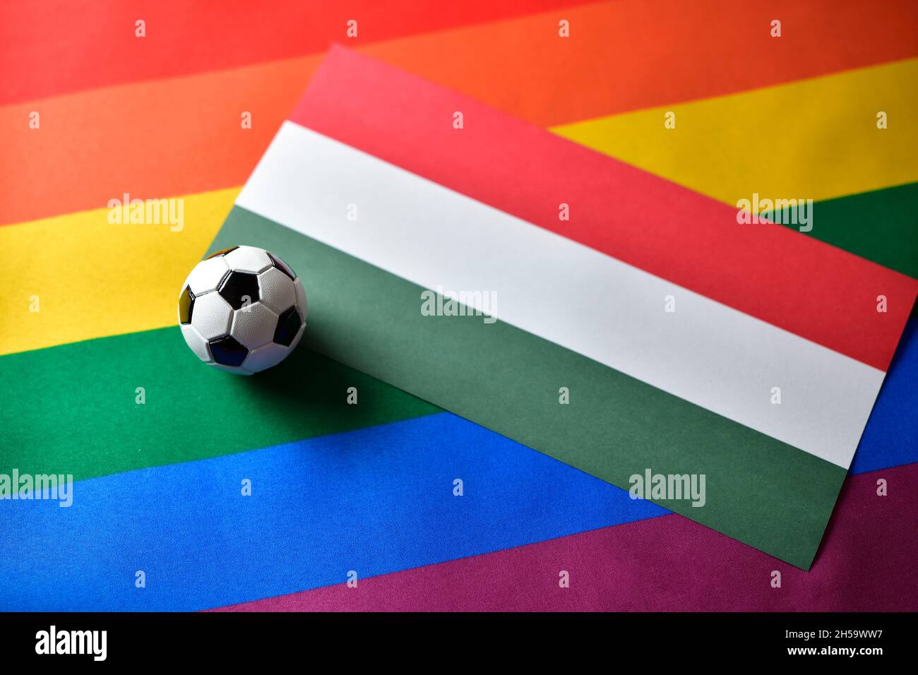 Miniaturfußball auf Fahne von Ungarn und Regenbogenfahne Stock Photo