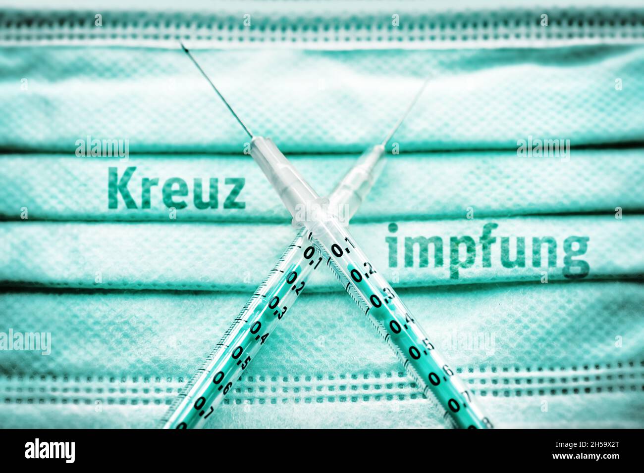 FOTOMONTAGE, Zwei gekreuzte Spritzen und Schriftzug Kreuzimpfung Stock Photo