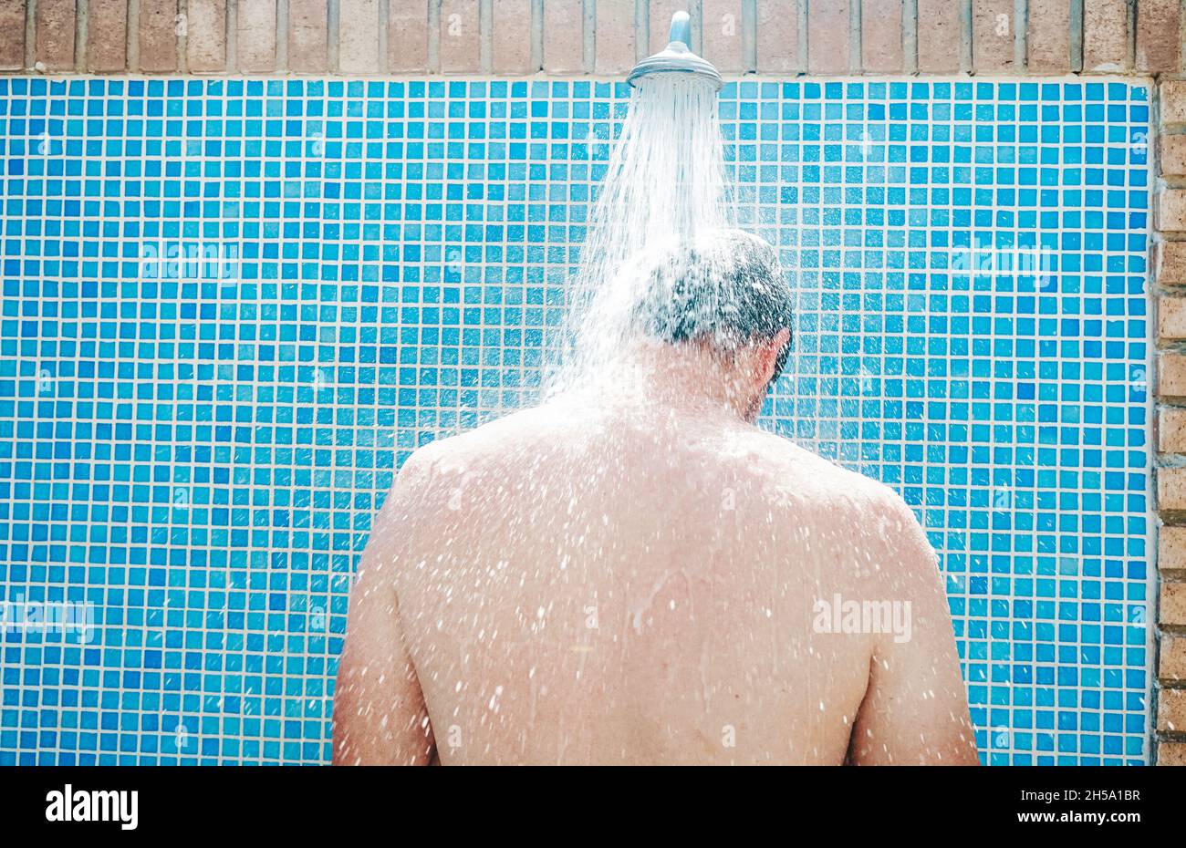 Young man having a shower before pool Stock Photo Alamy