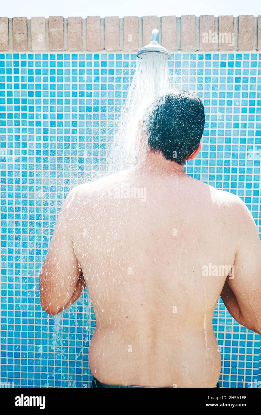 Young man having a shower before pool Stock Photo Alamy