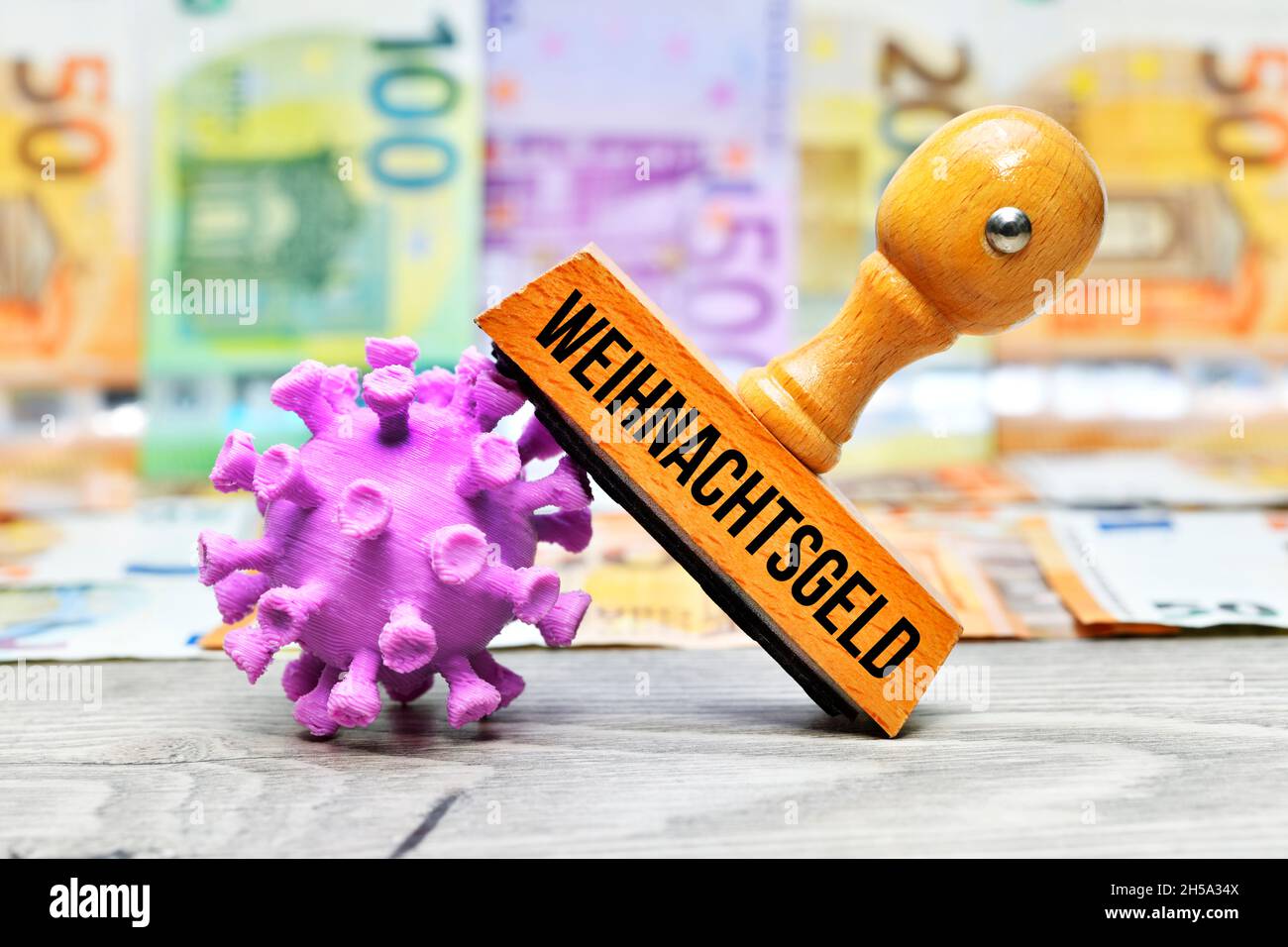 FOTOMONTAGE, Stempel mit Aufschrift Weihnachtsgeld und Coronavirus-Modell vor Geldscheinen Stock Photo