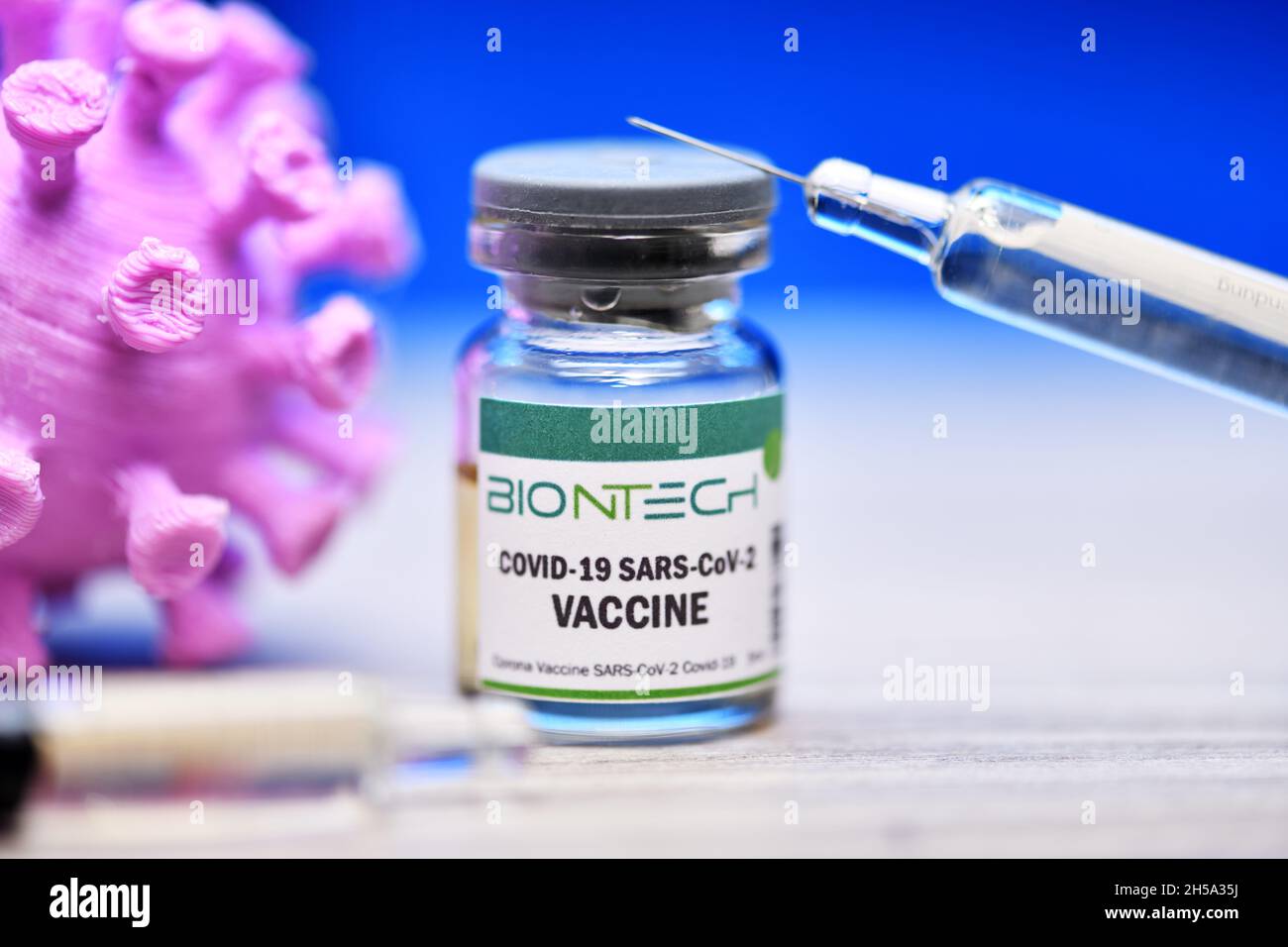 Injektionsflasche mit Impfspritze und Coronavirus-Modell, Corona-Impfstoff von Biontech, Symbolfoto Stock Photo