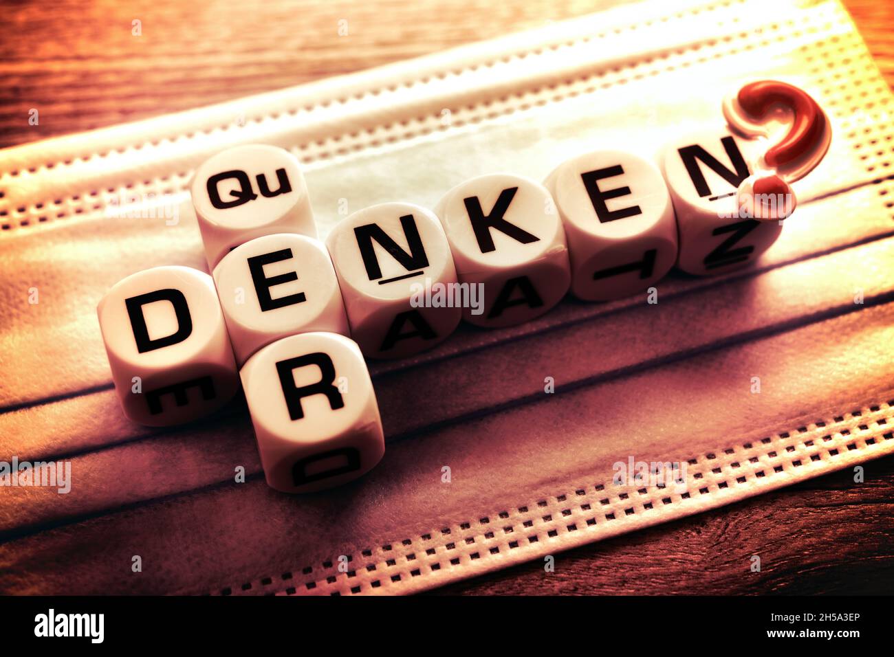 Buchstabenwürfel bilden die Worte 'quer' und 'denken' auf Schutzmaske, Symbolfoto Querdenker Stock Photo