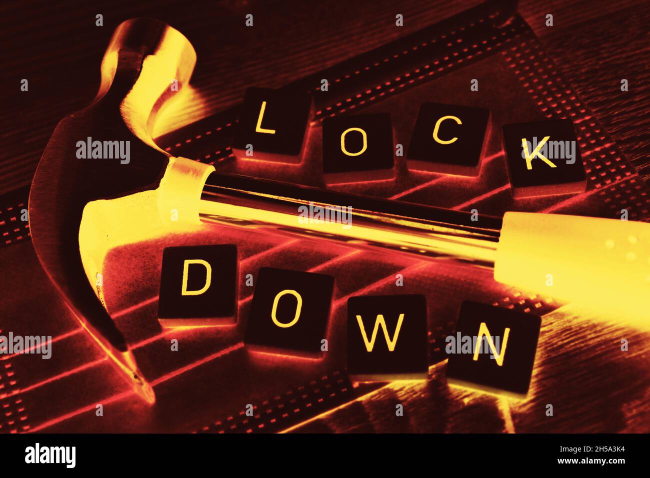 Hammer auf Schutzmaske und Schriftzug Lockdown, Symbolfoto harter Lockdown Stock Photo