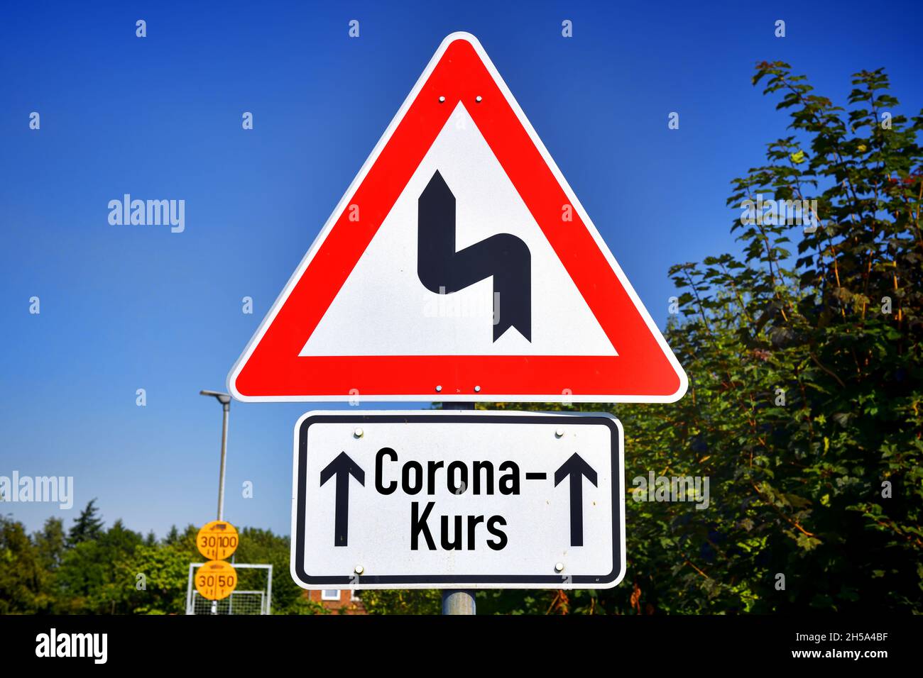 FOTOMONTAGE, Schild mit Kurvensymbol und Aufschrift Corona-Kurs, Symbolfoto fuer Schlingerkurs in der Corona-Pandemiebekaempfung Stock Photo