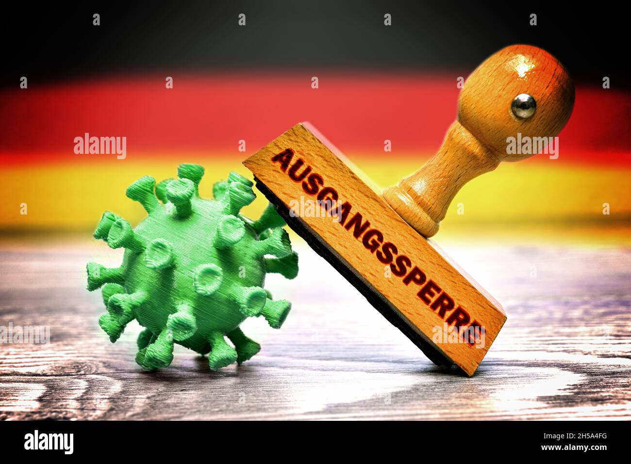 FOTOMONTAGE, Stempel mit der Aufschrift Ausgangssperre auf Coronavirus vor Deutschlandfahne, Symbolfoto Corona-Notbremse Stock Photo