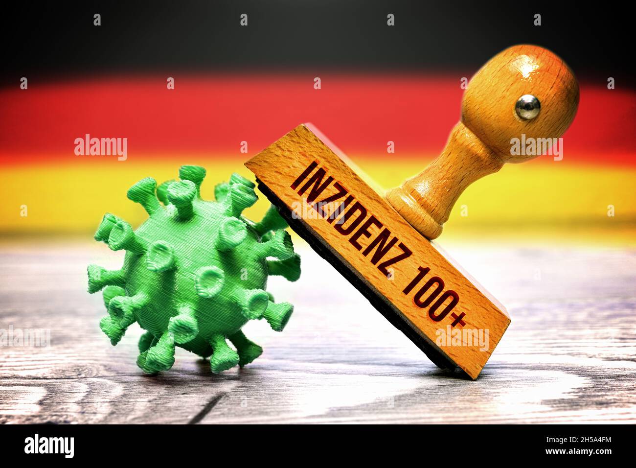 FOTOMONTAGE, Stempel mit der Aufschrift Inzidenz 100+ auf Coronavirus vor Deutschlandfahne Stock Photo