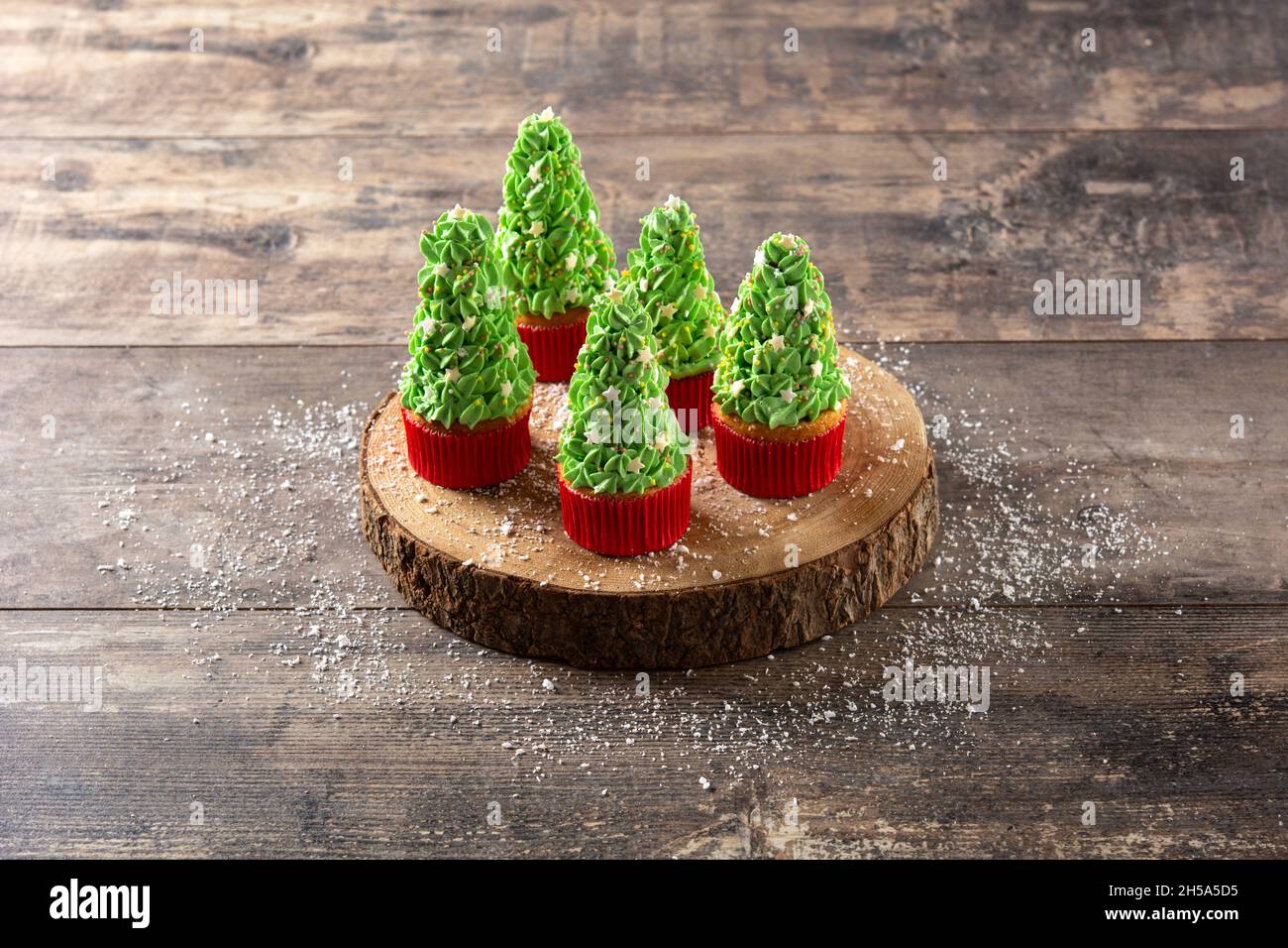 Christmas tree cupcakes on wooden table Stock Photo