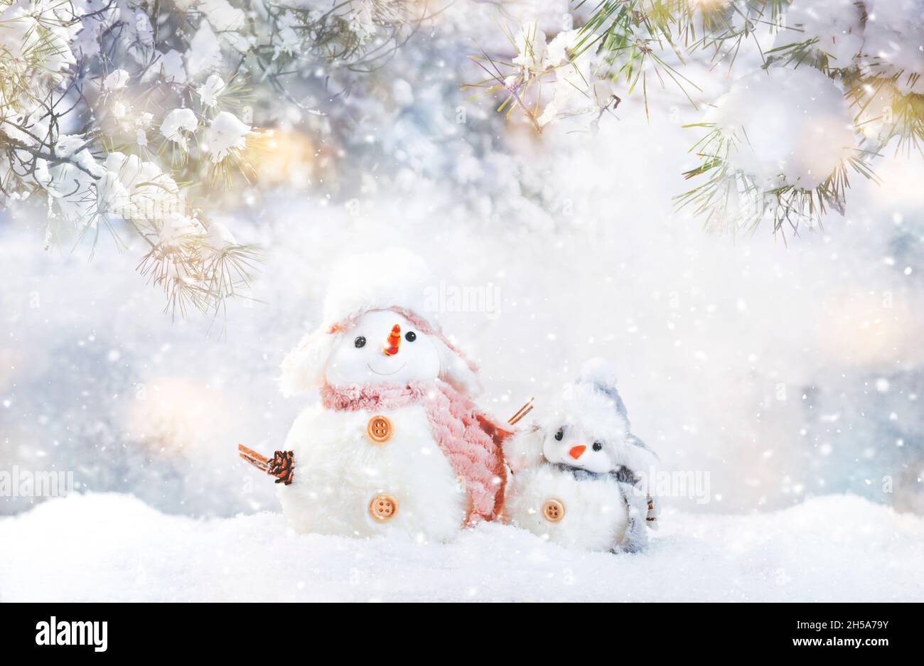Christmas and new year snow concept with two cute snowmen in hats and ...