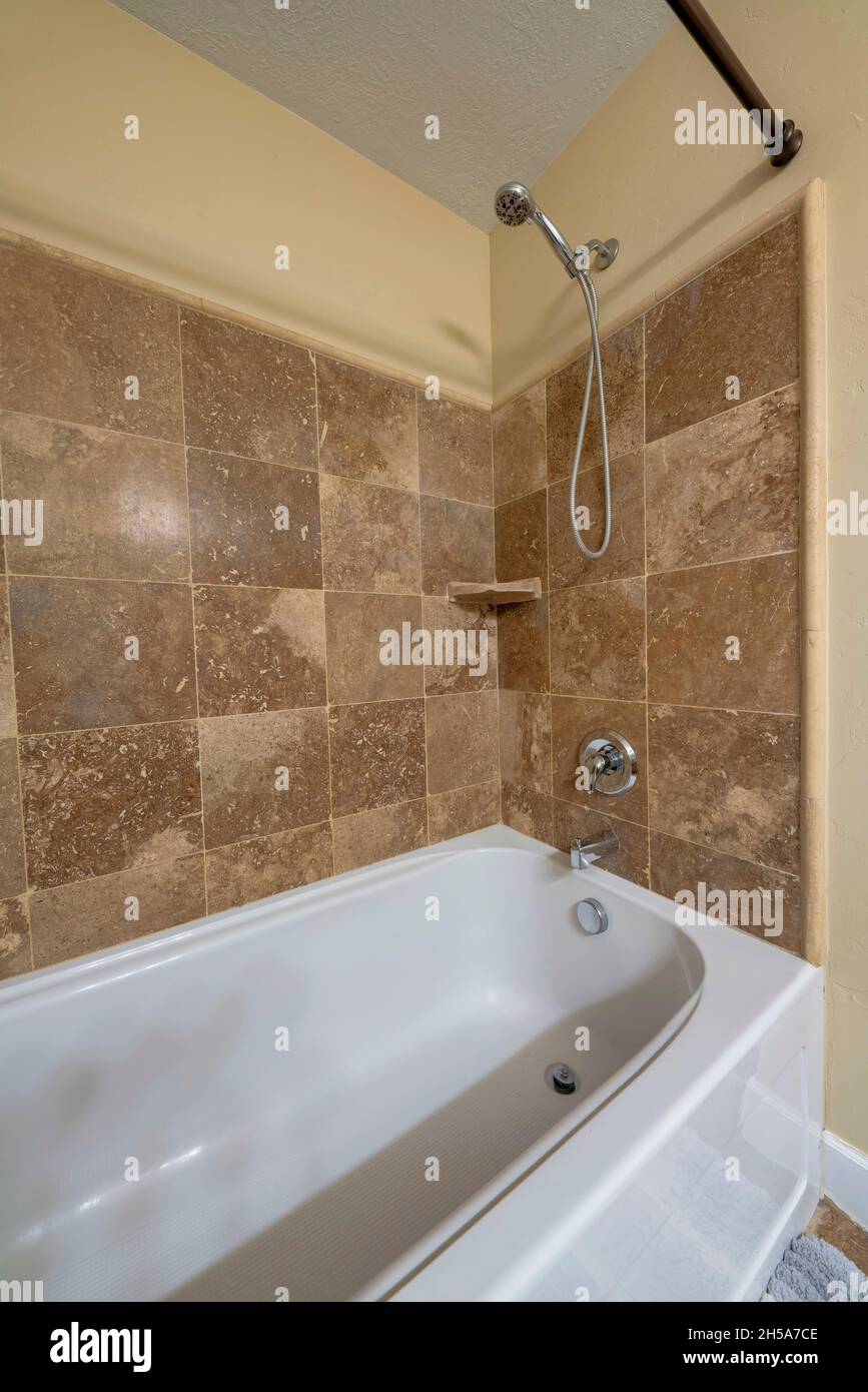 Bathtub with wall mounted handheld shower head and faucet Stock Photo