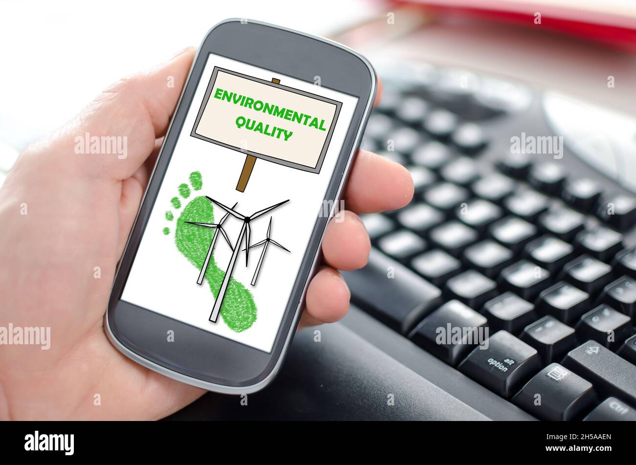 Hand holding a smartphone showing an environmental quality concept ...