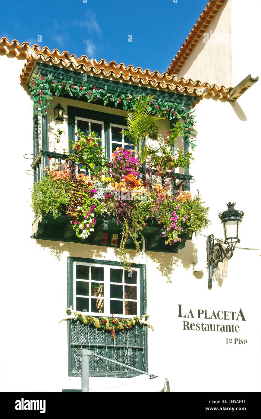 Santa Cruz de La Palma, Canary Islands - December 8, 2019: old wooden balcony with lots of plants and christmas decorations on a restaurant building. Stock Photo