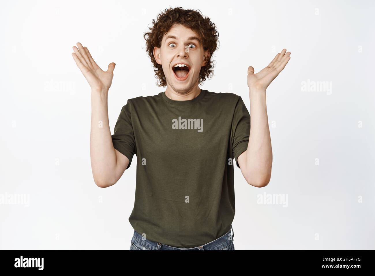 Excited curly guy clap hands, shouting amazed and aplause, heart ...