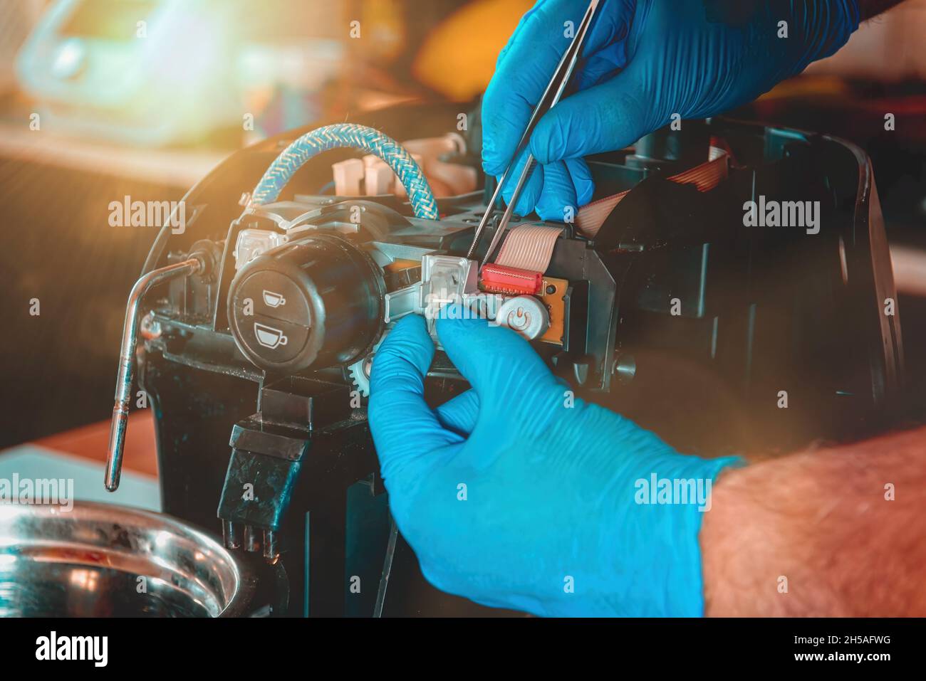 A repairman fixes a broken coffee maker, repair of household appliances Stock Photo