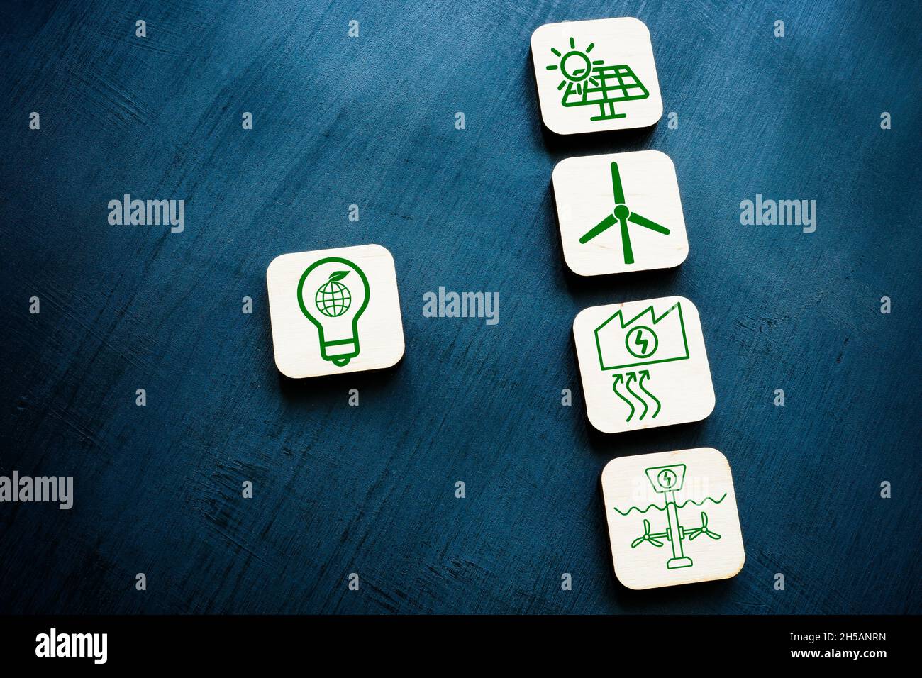 Renewable resources or green energy concept. Wooden cubes on the dark surface. Stock Photo