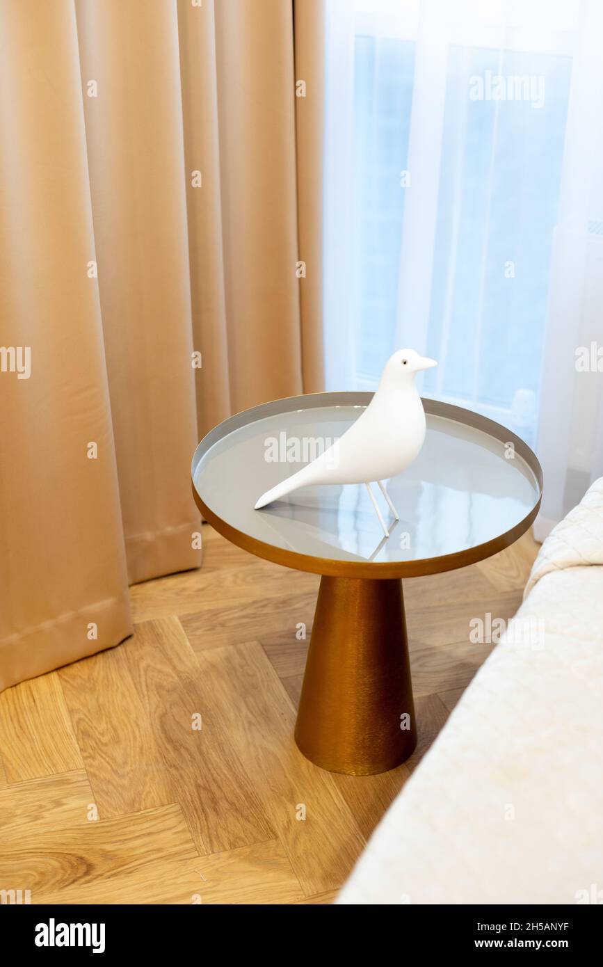 Glass round bedside table with gold in a modern beige interior